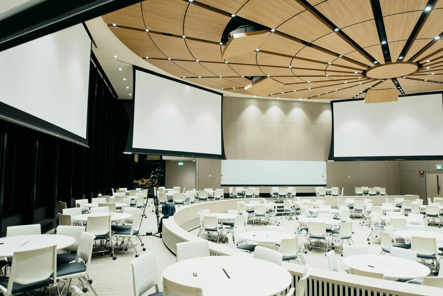 Conference venue with round tables and presentation screens