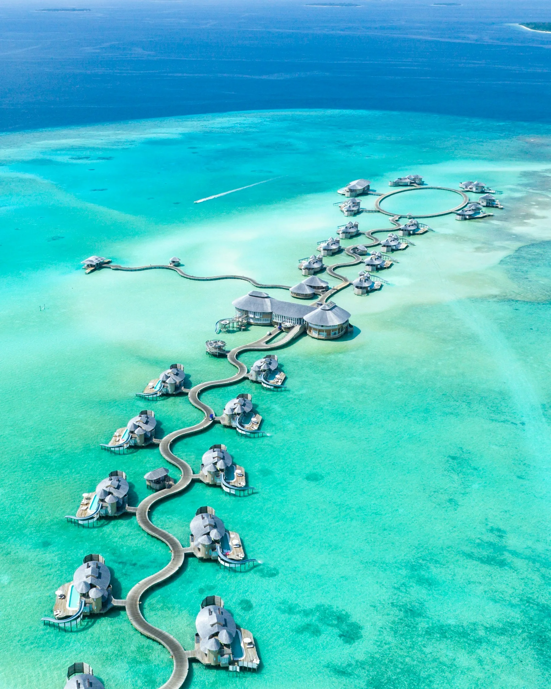 Overwater villas surrounded by turquoise lagoon water in the Maldives
