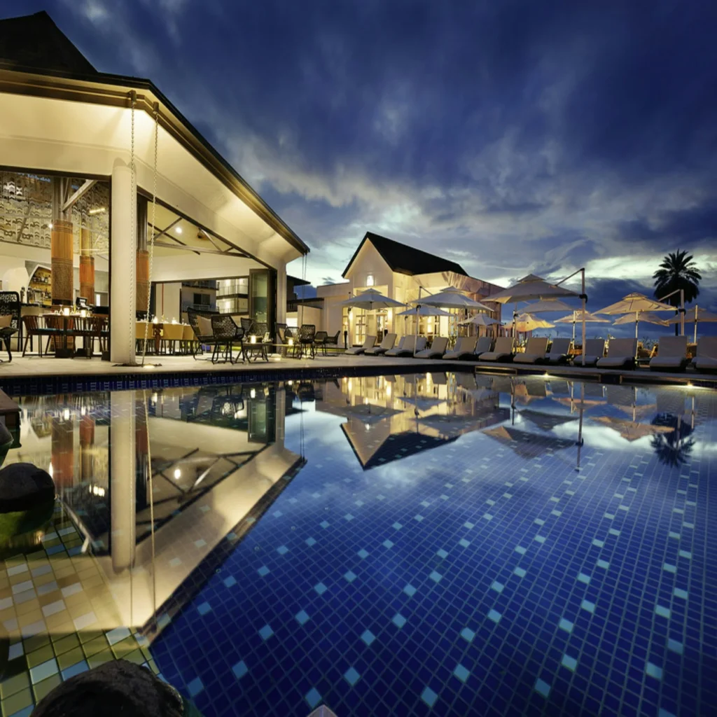 Resort buildings and swimming pool at dusk